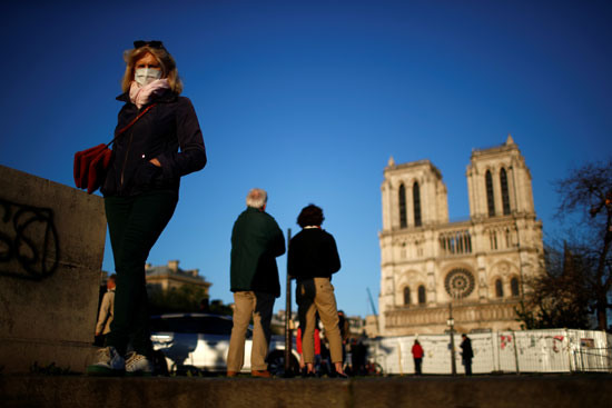 يستمع الناس إلى رنين الجرس الكبير بكاتدرائية نوتردام دي باريس ، كعلامة على مرونة المبنى بعد عام واحد من حريق مدمر