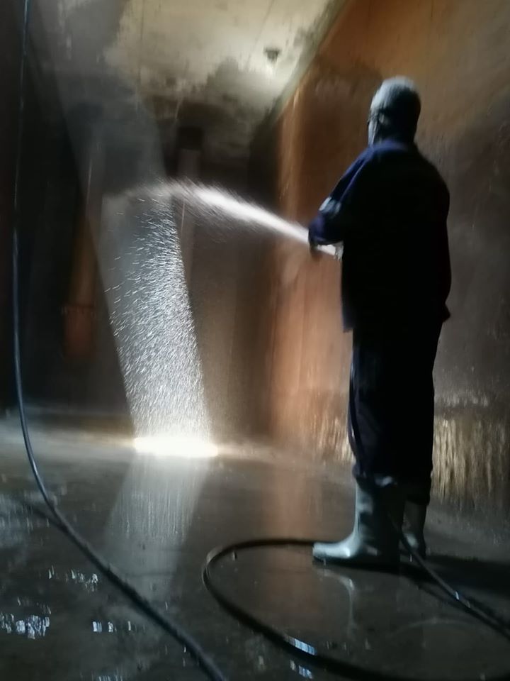 رجال شركة المياه خلال تعقيم وتطهير الخزانات الأرضية بالبعيرات