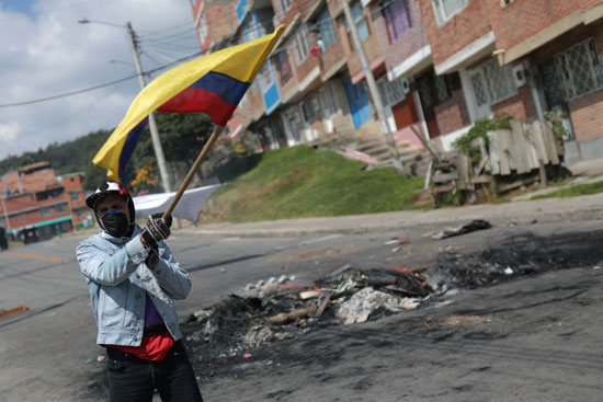 متظاهر يرفع علم كولومبيا