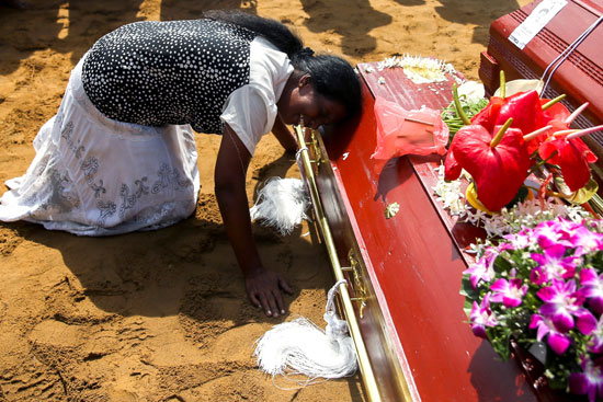 سيدة تبكى أثناء دفن جماعي للضحايا