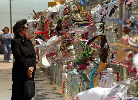 سيدة تقف أمام النصب التذكارى للضحايا