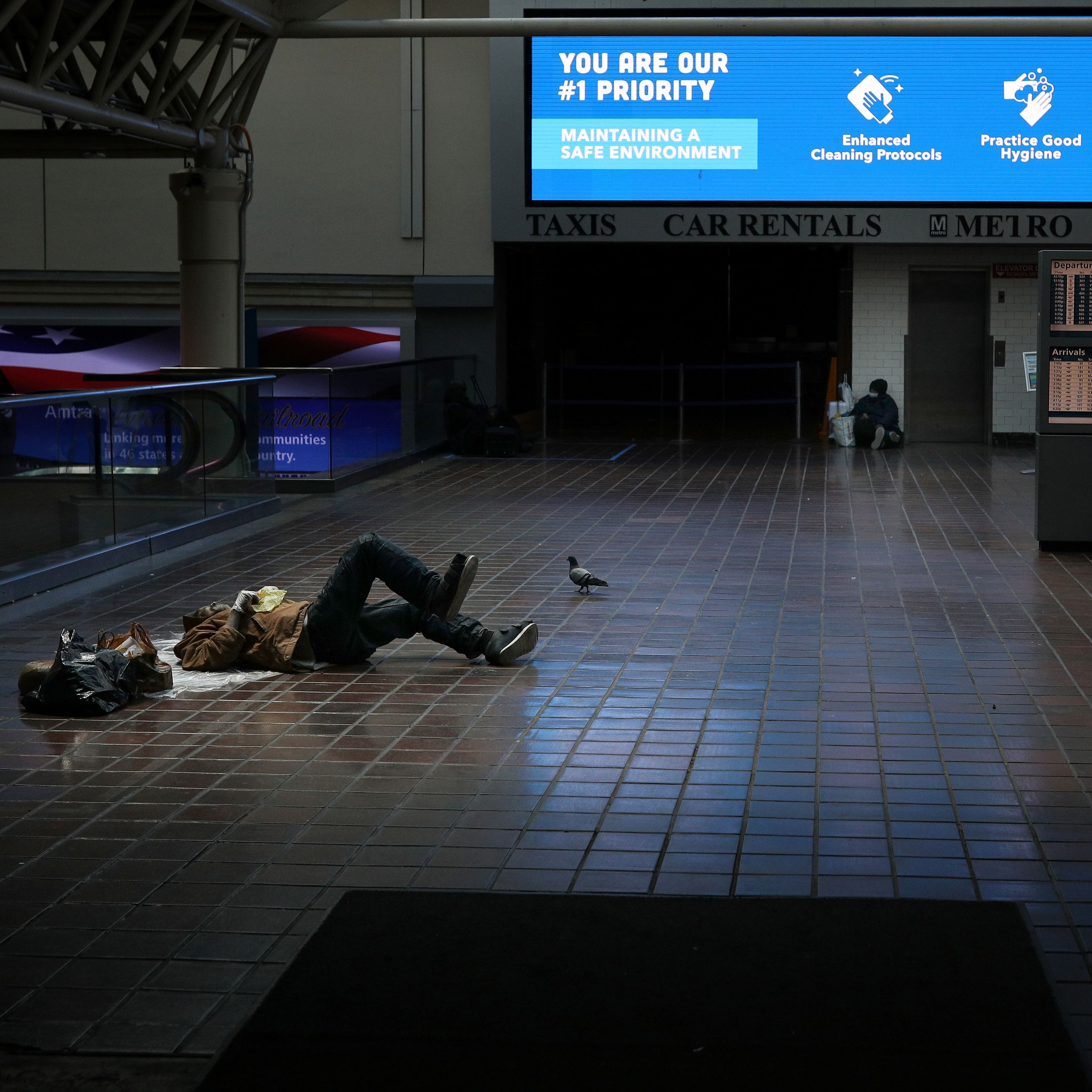 احد المشردين يفترش الأرض امام محطة قطار بأمريكا