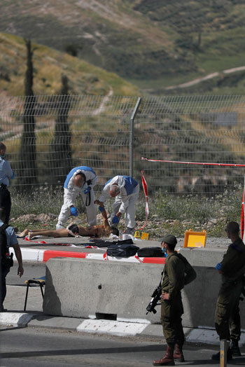 فريق طبى يقوم بالكشف على جثمان الفلسطينى منفذ الهجوم