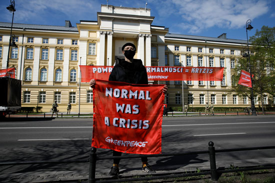 أحد النشطاء فى بولندا يرفع لافتة للحفاظ على البيئة فى يوم الأرض