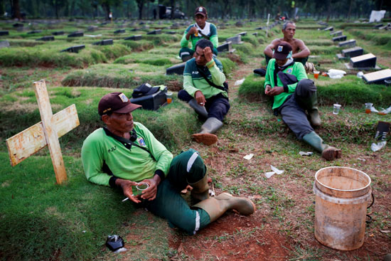 حفارو القبور وهم ينتظرون توابيت جديدة بإندونيسيا
