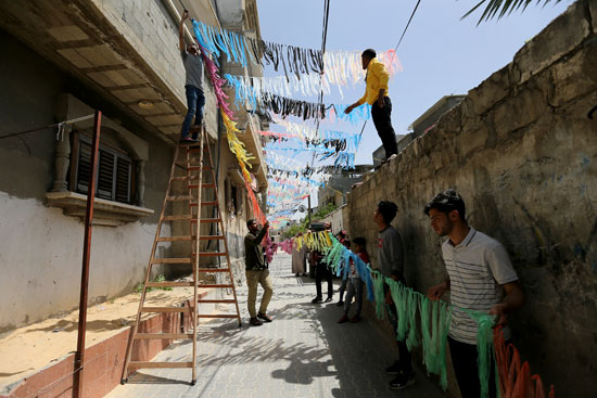 فلسطينيون يزينون حيًا قبل شهر الصوم المبارك