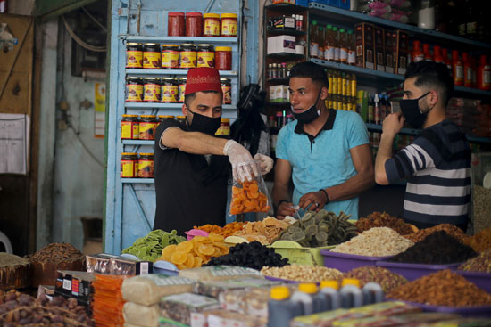 بائع فلسطيني يبيع منتجات غذائية مجففة في سوق قبل شهر رمضان المبارك