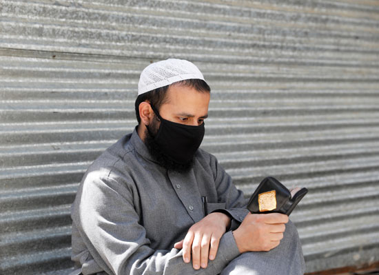 رجل يقرأ القرءان مرتديا الكمامة بأفغانستان
