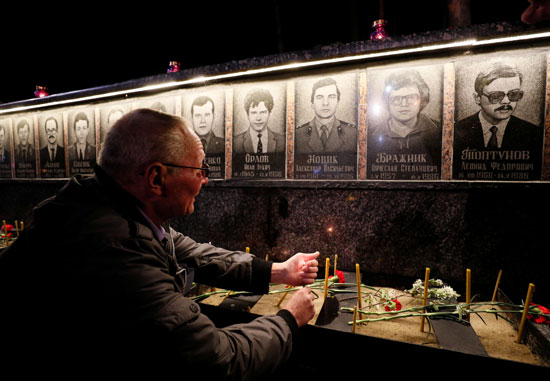 عجوز ينظر لصور الضحايا فى النصب التذكارى