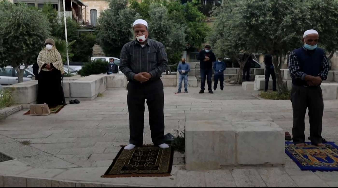 الصلاة فرادى أمام أبواب المسجد الأصى المغلقة