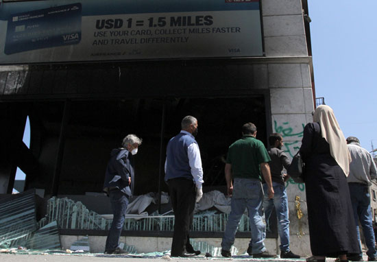 تجمع عدد من اللبنانيون خارج مقار أحد البنوك بعد تحطيمه