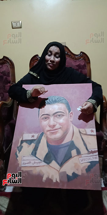 أم الشهيد خالد مغربي دبابة مع صورة للشهيد (1)