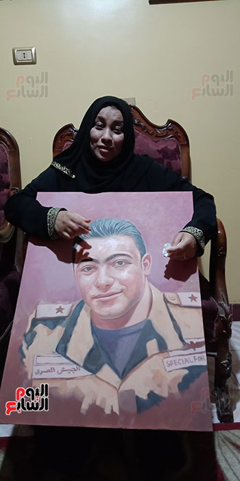 أم الشهيد خالد مغربي دبابة مع صورة للشهيد (2)