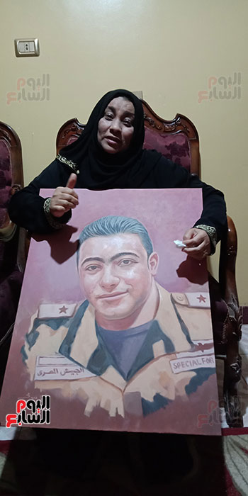 أم الشهيد خالد مغربي دبابة مع صورة للشهيد (4)