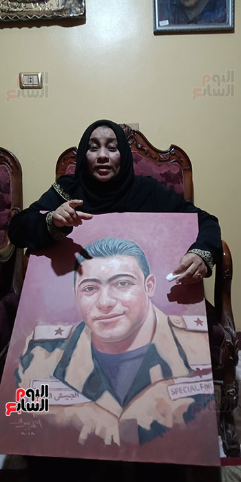 أم الشهيد خالد مغربي دبابة مع صورة للشهيد (6)
