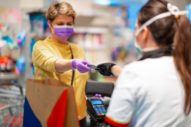 1_Cashier-returning-credit-card-to-woman-in-mask-and-gloves