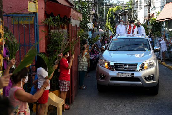 كاهن يتجول بسيارته فى الشوارع الفلبينيه ليبارك المحتفلين أمام منازلهم