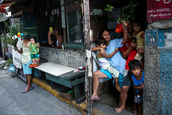 الفلبينيين يتجمعون أمام منازلهم انتظارا لعبور الكاهن