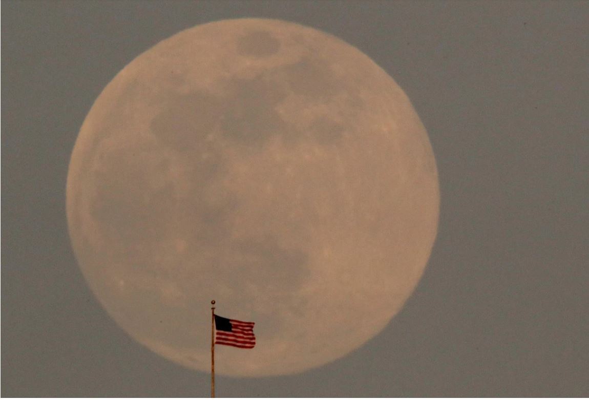 القمر العملاق وأمامه علم أمريكا
