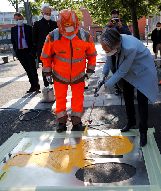 إليزابيث بورن ، الوزيرة الفرنسية للتحول الإيكولوجي والشامل  ترش طلاءًا أصفر على علامة ممرات الدراجات الجديدة