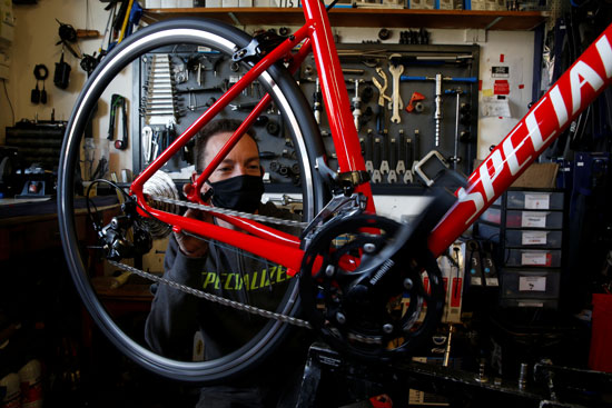 يقوم الدراج والميكانيكي رومان بايلي بإصلاح دراجة في متجر الدراجات الخاص به في ماركوينج