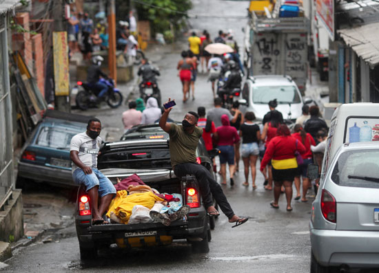 السكان ينقلون الجثث بعد عملية للشرطة ضد عصابات المخدرات في مجمع الأحياء الفقيرة في أليماو في ريو دي جانيرو