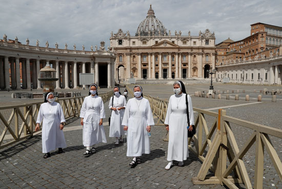 الراهبات يمشين في يوم إعادة افتتاح كنيسة القديس بطرس بالكامل حيث يخفف الفاتيكان من التدابير