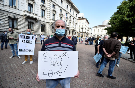 رجل يحمل لافتة أثناء مشاركته في احتجاج أمام مبنى البلدية