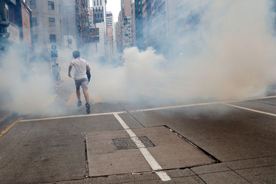 أحد المتظاهرين تحيطه أدخنة الغازات المسيلة للدموع