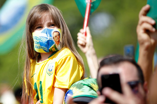 فتاة برازيلية تدعم الرئيس بالكمامة