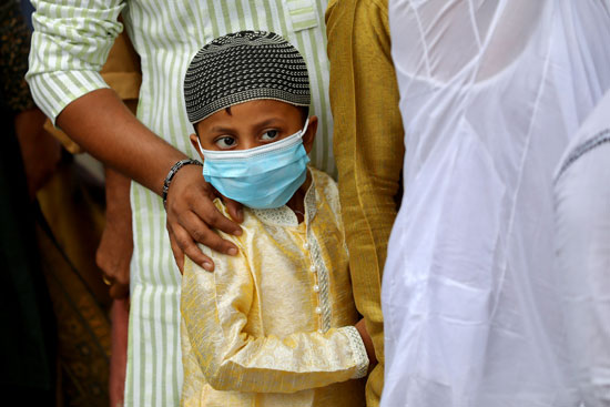 طفل يرتدى كمامة خلال توجهه لصلاة العيد فى بنجلاديش