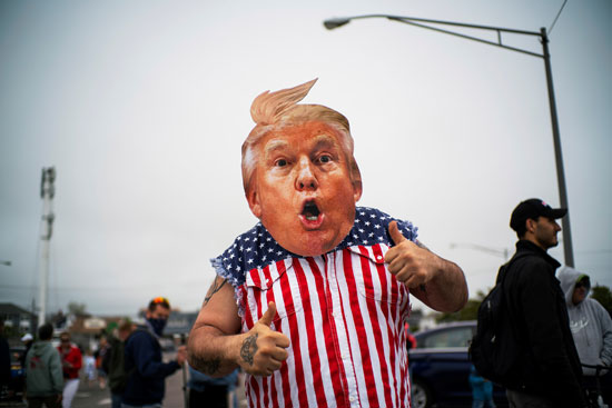 أحد المتظاهرين يرتدي قناعا على شكل ترامب