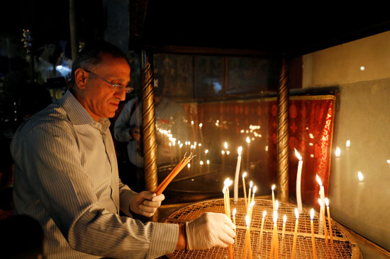 زائر يشعل الشموع في كنيسة المهد أثناء إعادة فتحها
