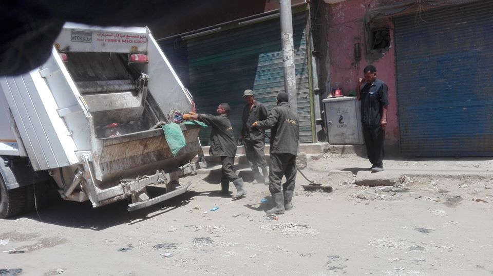 رجال النظافة خلال رفع المخلفات والقمامة من شوارع اسنا