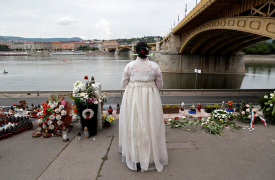 امرأة ترتدي لباسًا كوريًا تقليديًا تنعي الضحايا في الذكرى السنوية الأولى لحادث قارب ميرميد بالقرب من جسر مارجريت