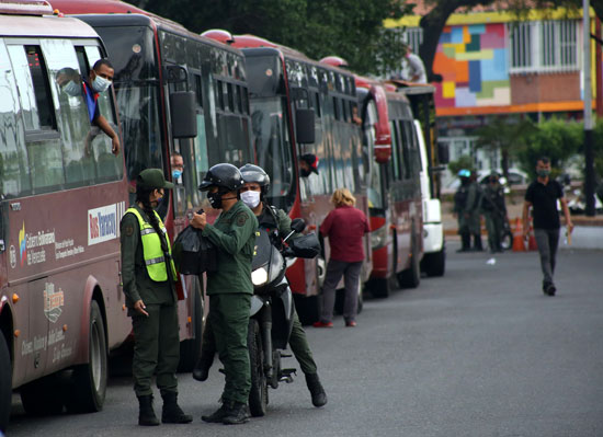 الحرس الوطني البوليفاري يقفون بجوار الحافلات قبل دخولها فنزويلا