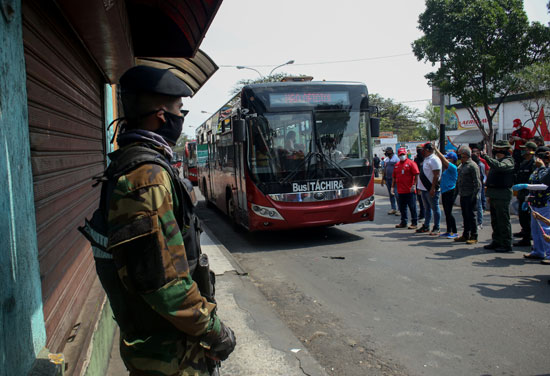 الحرس الوطنى البوليفى بجوار الحافلة قبل وصولها فنزويلا بعد إنقضاء الـ 14 يوم عزل طبى