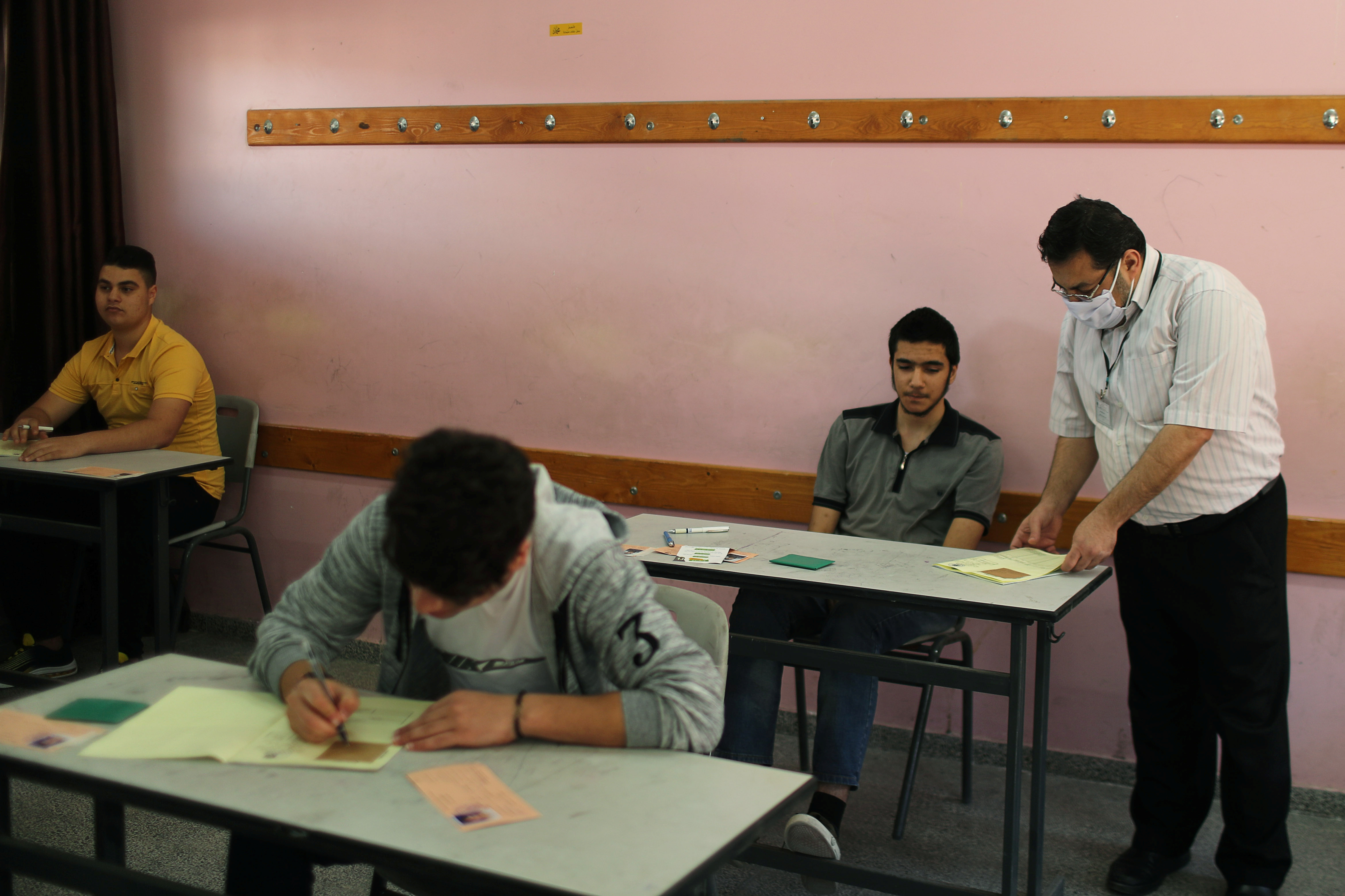 مراقب أثناء مشاهدة الطلاب الفلسطينيين امتحانات الثانوية العامة في فصل دراسي