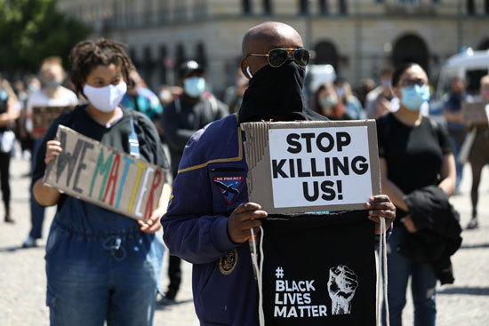 رجل من أصل أفريقى يرفع لافتة لا تقتلونا فى برلين