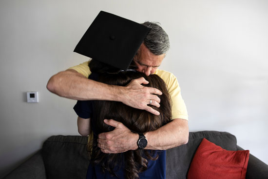 والد الطالبة يحتضنها بعد نهاية الحفل