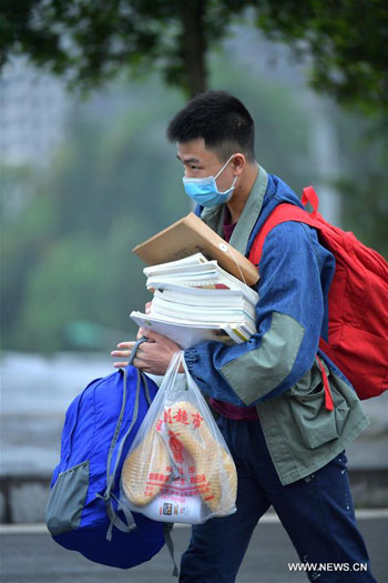 طالب يحمل كتبه خلال عودته للدراسة
