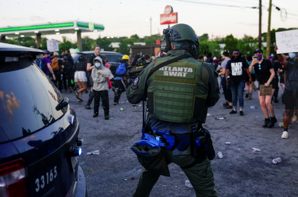 أحد عناصر القوات الخاصة يوجه سلاحه على المتظاهرين