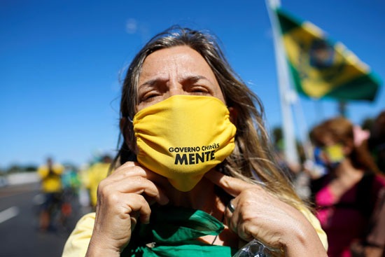 متظاهرة برازيلية بالكمامة
