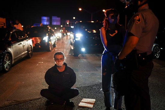 أحد المتظاهرين يجلس على الأرض بعد اعتقاله