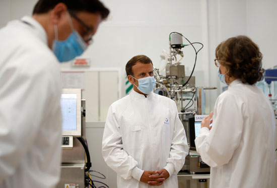 إيمانويل ماكرون يرتدى ملابس التعقيم