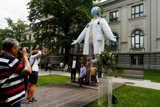 عدد من الزائرين يلتقطون الصور التذكارية مع التمثال