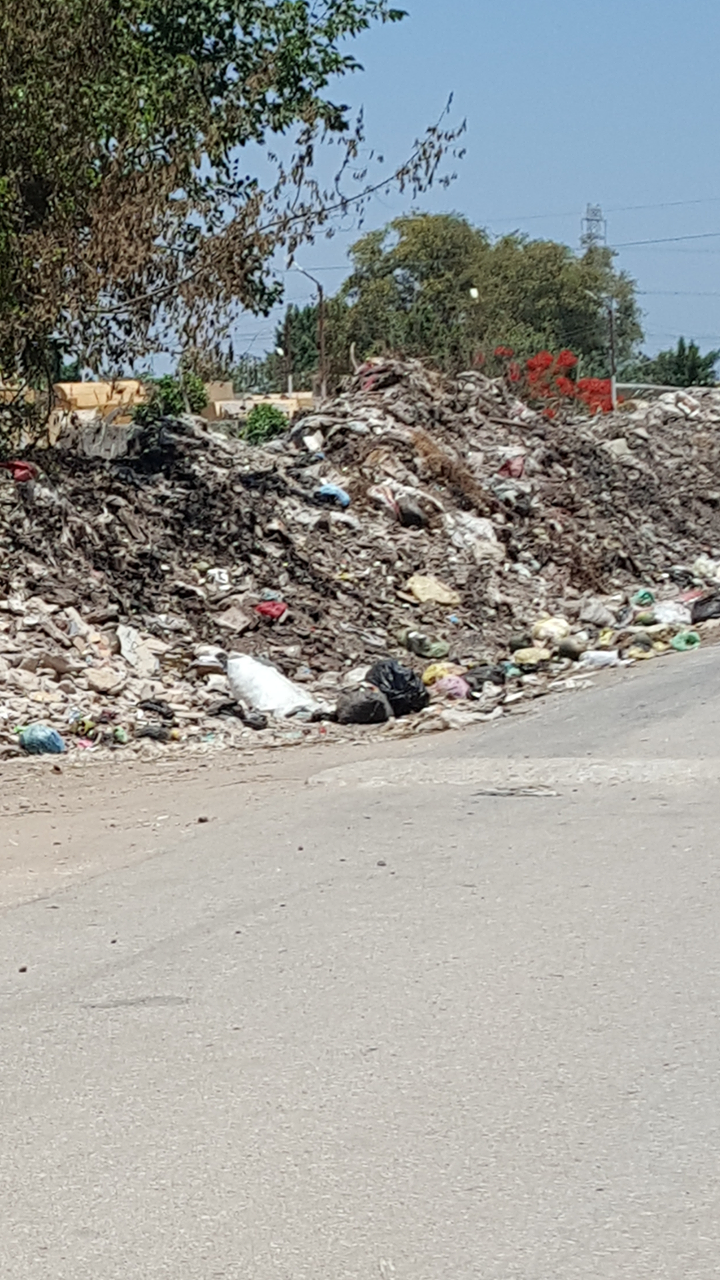 تلال القمامة والمخالفات على جانبي الطريق