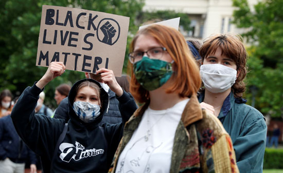 المتظاهرون يرتدون الكمامات ويرفعون لافتات  حياة السود مهمة