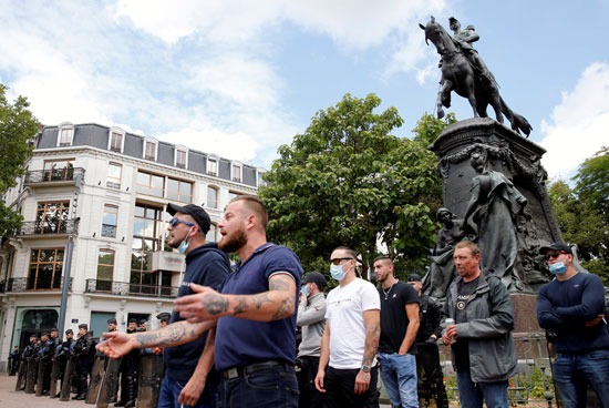 رد فعل المتظاهرين المضادين بينما يقف ضباط الشرطة في حالة حراسة بجانب تمثال الجنرال فيدهيربي