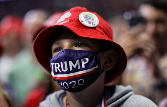 طفل يرتدى كمامة مكتوب عليها ترامب 2020
